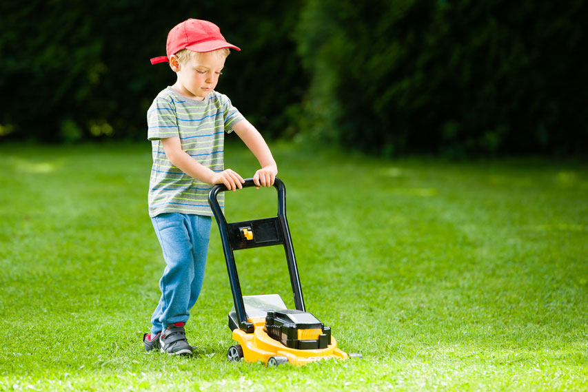 Picture of boy mowing grass.